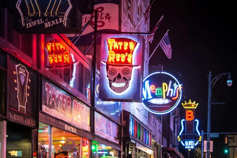 a city street at night decorated with brightly lit signs and advertits