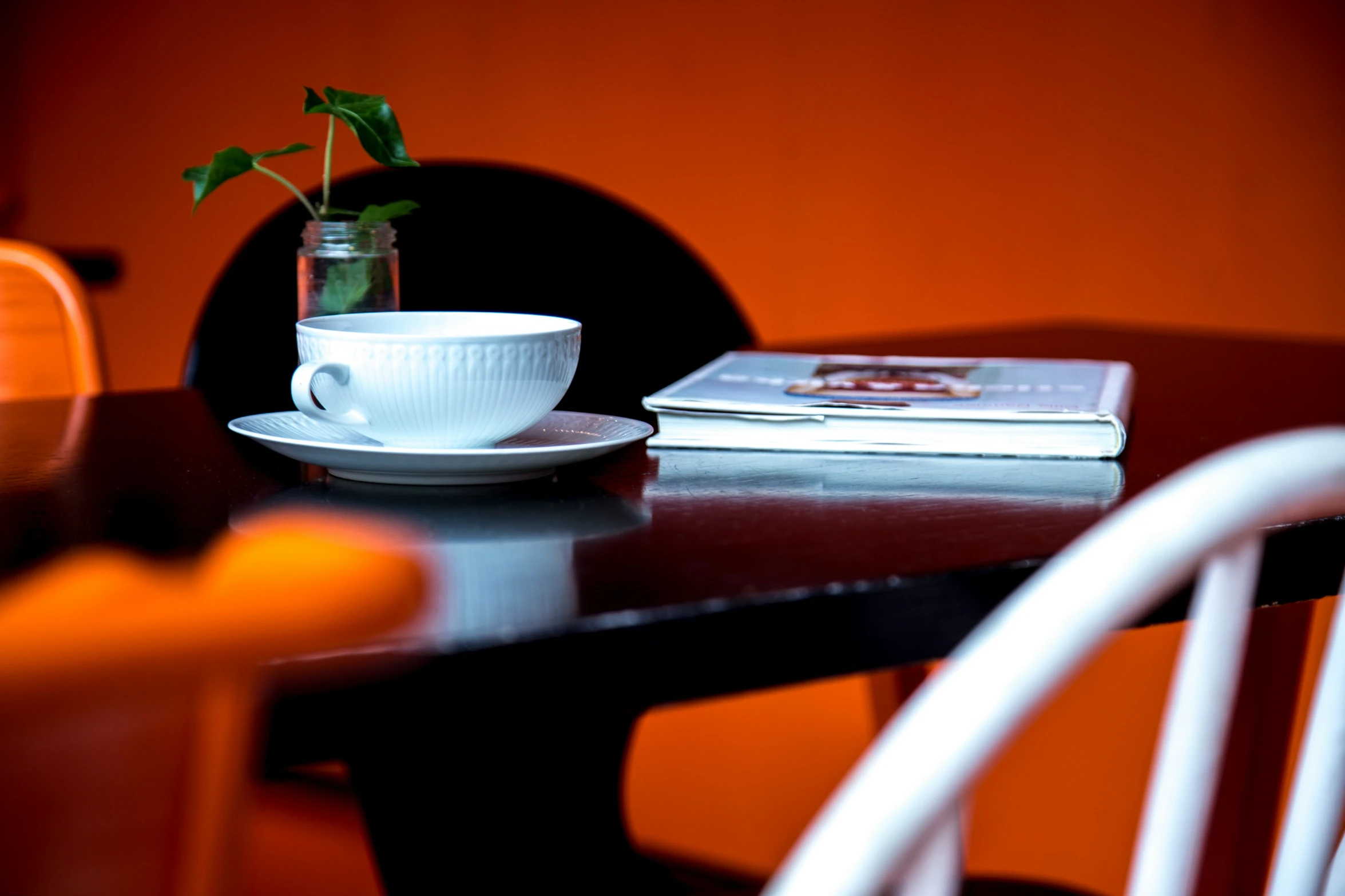 a table topped with a vase filled with a green plant