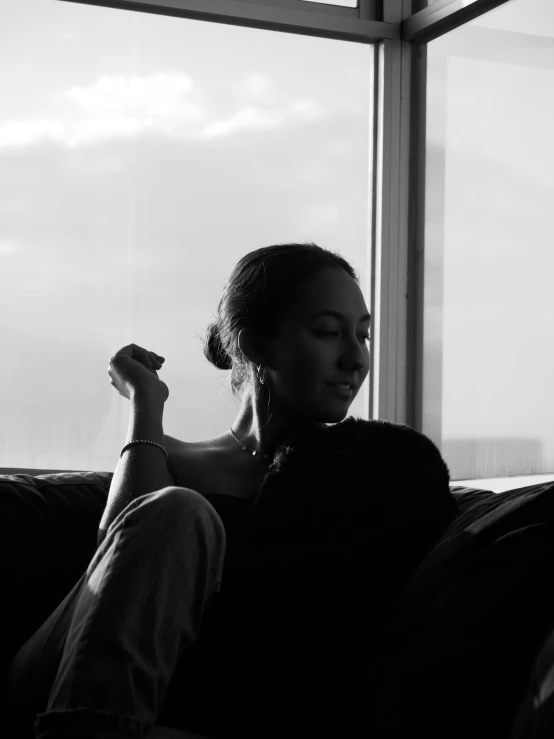 a young woman laying on a couch with a cat