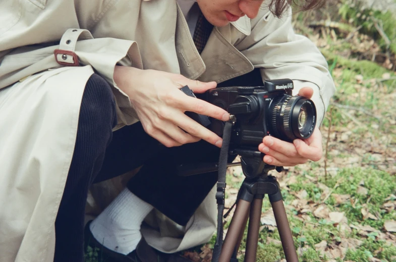 woman taking pograph on small tripod near field