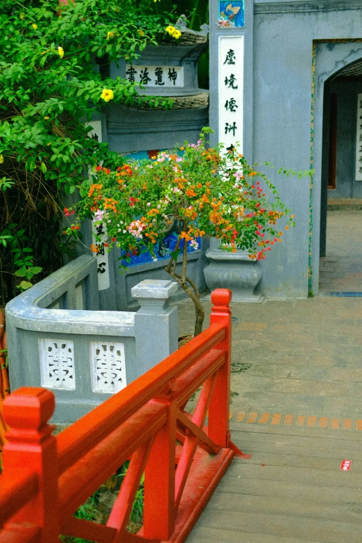 a red bench sitting next to a small orange gate