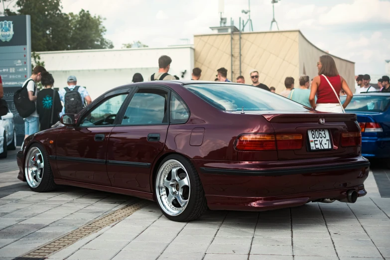 a maroon honda car parked at an event