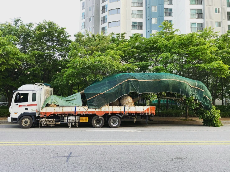 a white truck parked by a covered canopy in the middle of a parking lot