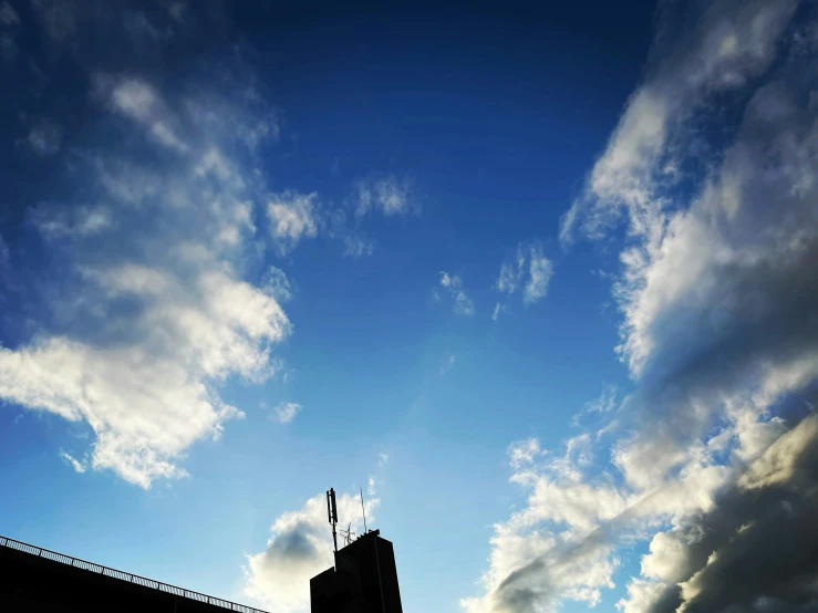 a building with a large clock tower under the clouds