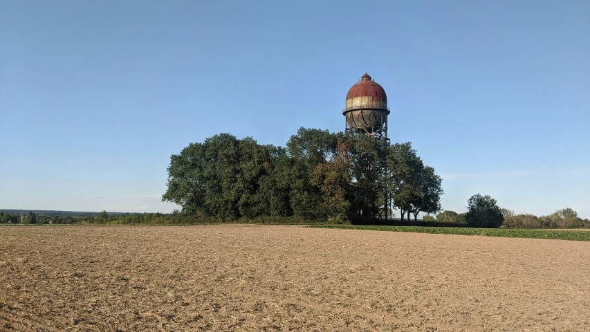 a dirt field next to a red fire hydrant