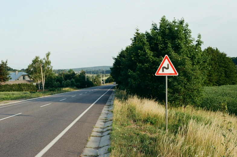 a red and white traffic sign in a grass field