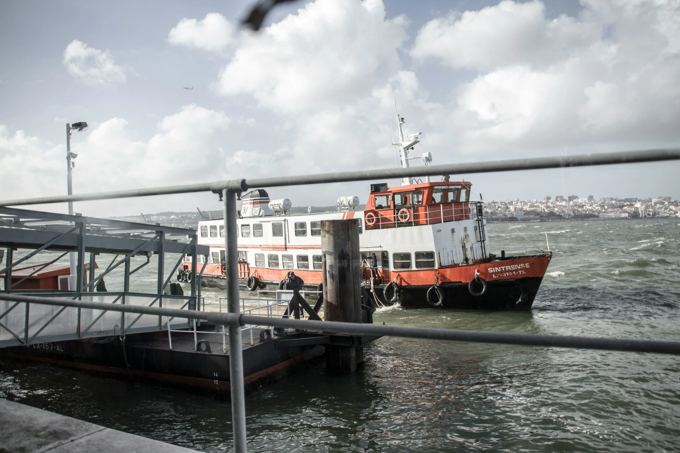 ferry boat approaching a dock with passengers boarding