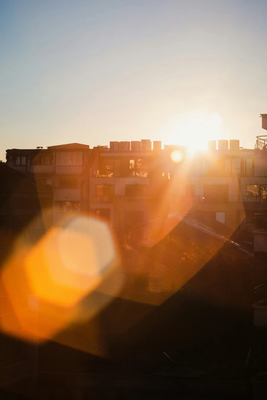 a view of the sun setting behind a city