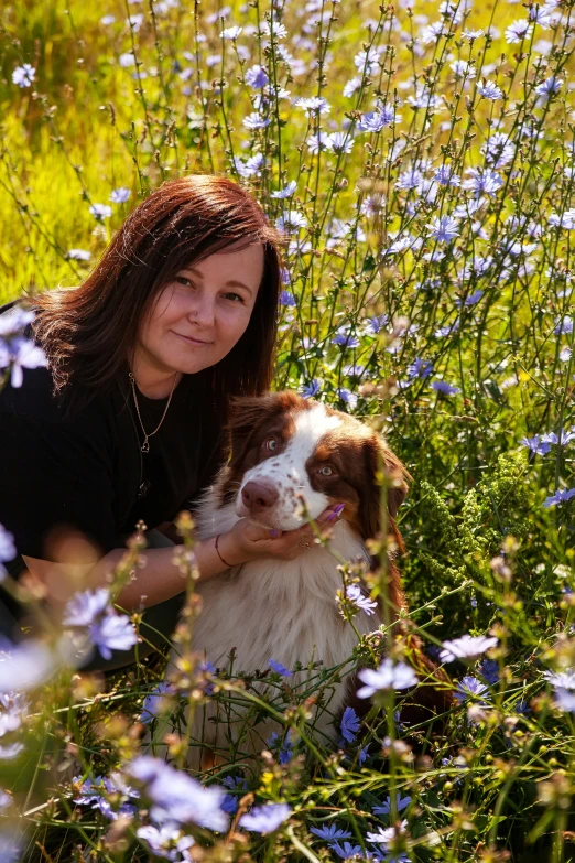 a woman and her dog in a grassy field