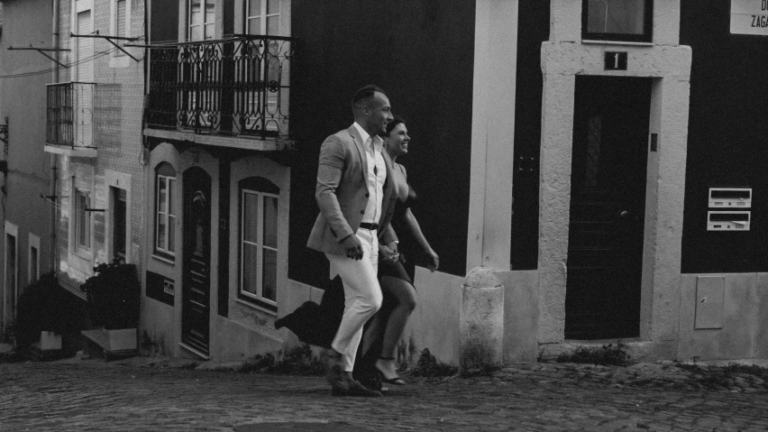 two men walking past an old building with doors