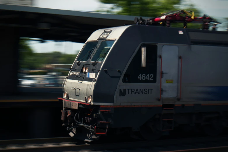 a passenger train traveling down tracks next to a sidewalk