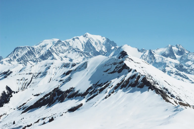 a snow capped mountain with a ski trail in front