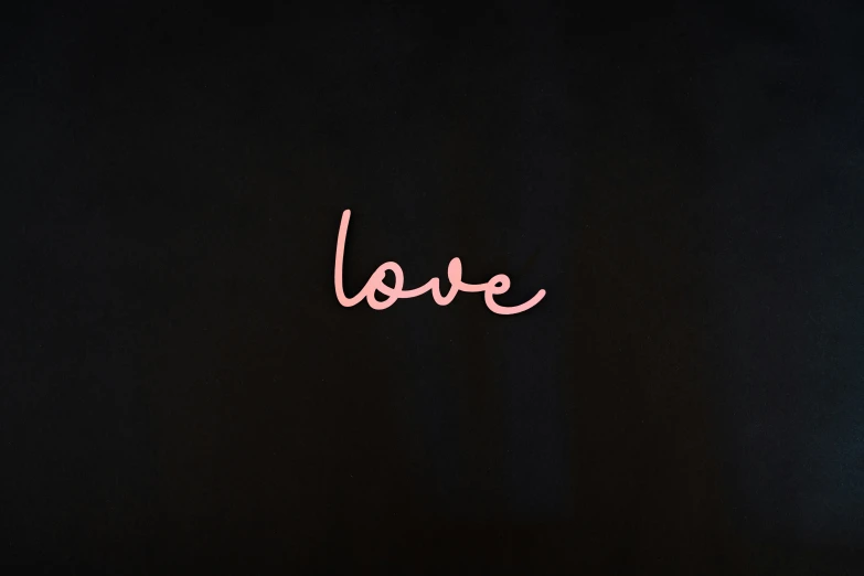 the words love written with pink neon lights on a black background