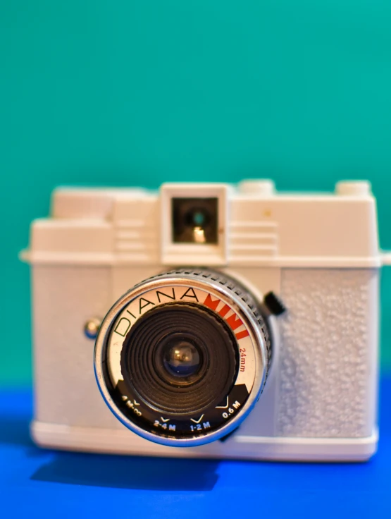 an old camera sitting on top of a blue surface