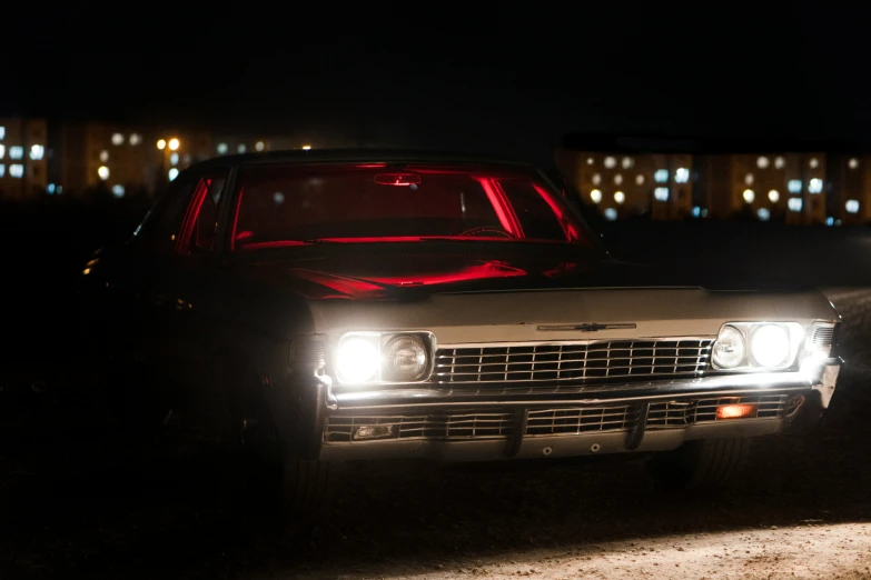 a car is illuminated in the dark by some building