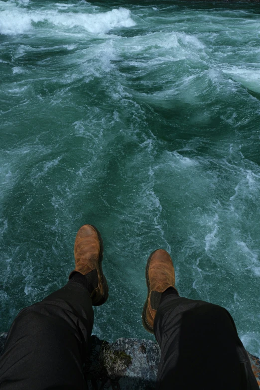 two people are standing in the water of a river