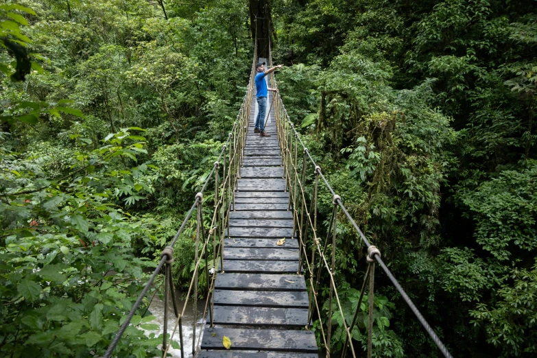 a person is walking across a rope bridge