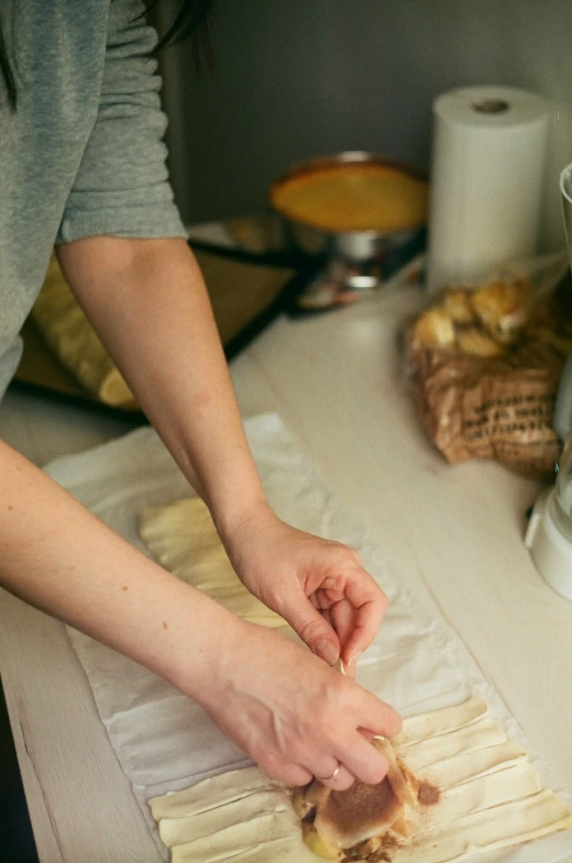 a woman is placing food onto some paper on the counter