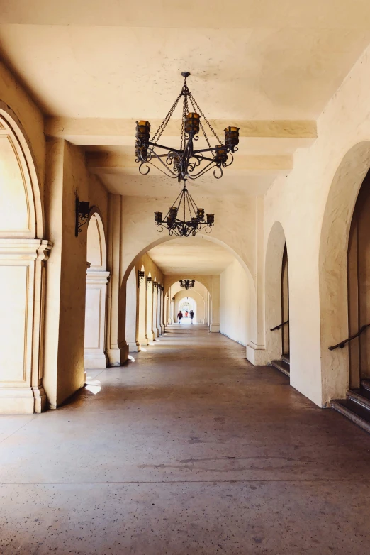 a view of a hallway with many arches and chandeliers