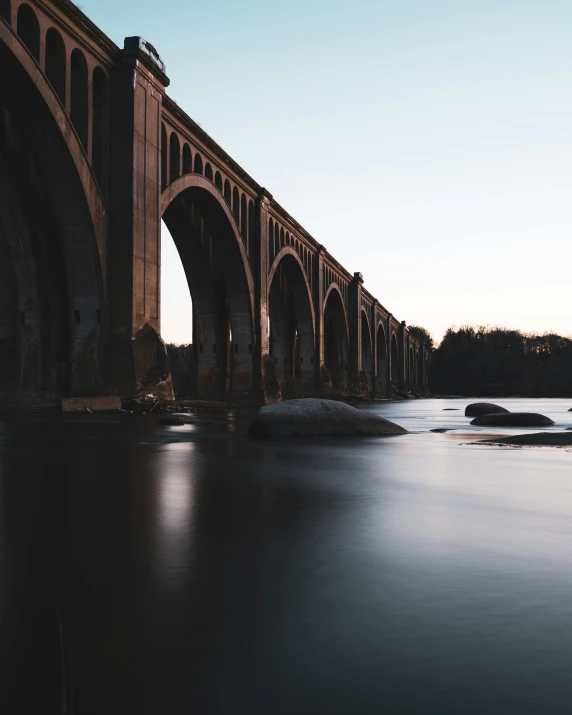 there is an old bridge that is reflecting in the water