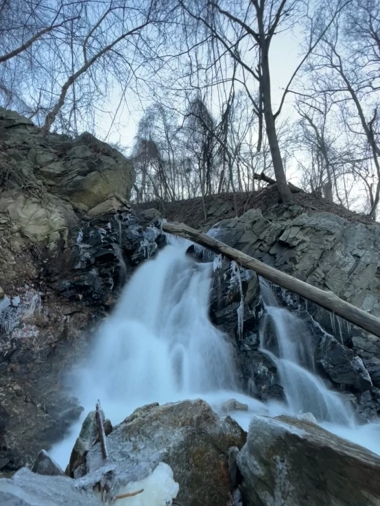 the waterfall on the rocks has ice on it