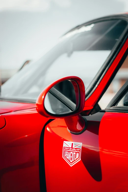 an image of a mirror on a car that is red