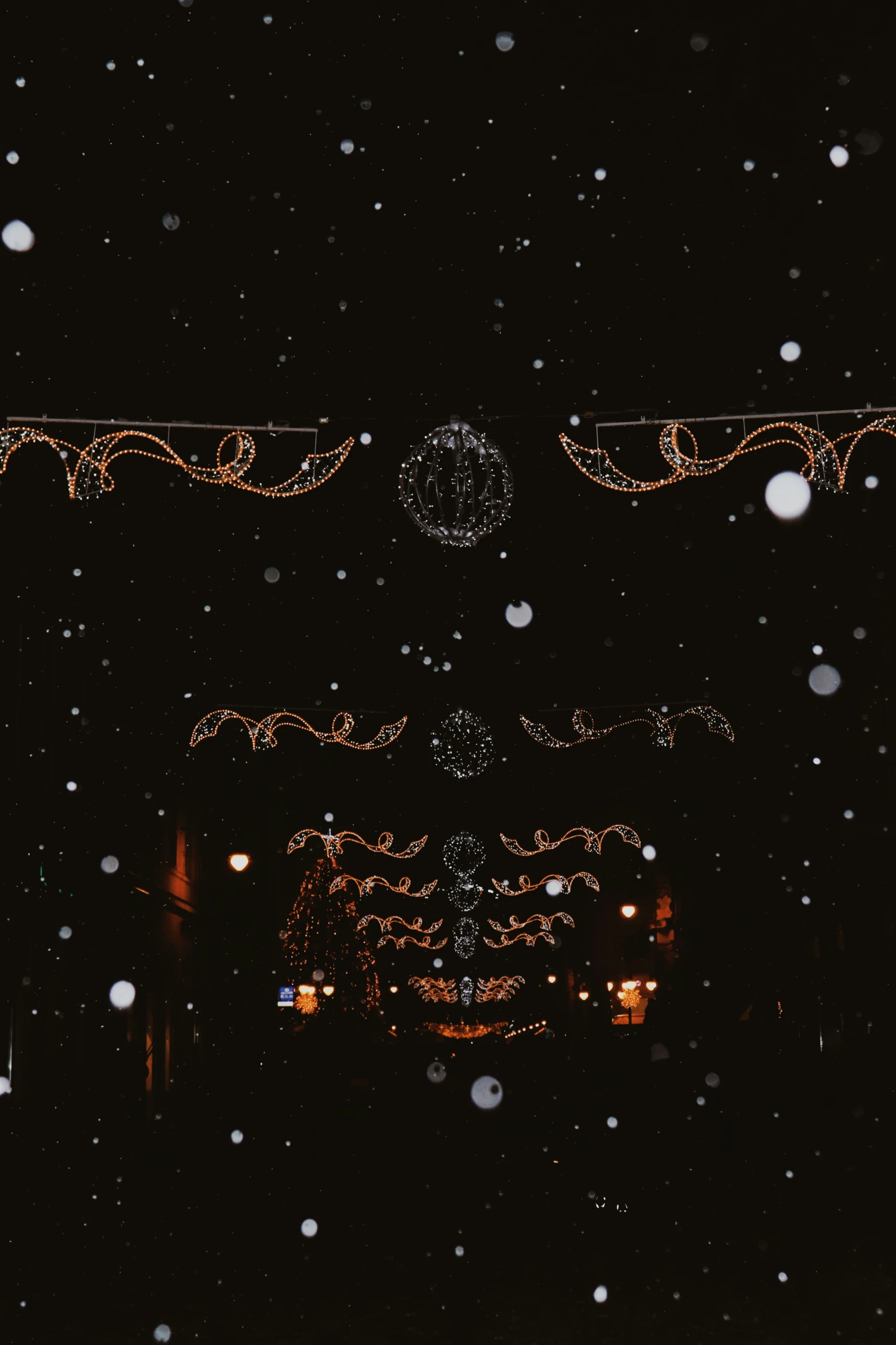 light decorations and lights in the dark with snow falling on it