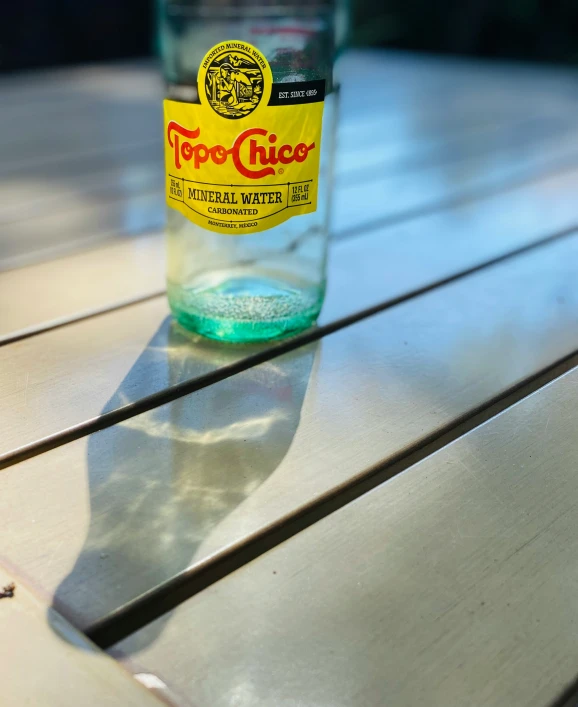 a bottle sitting on top of a wooden bench