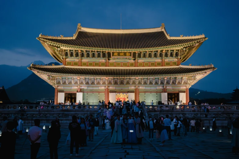 many people stand around in front of a tall building