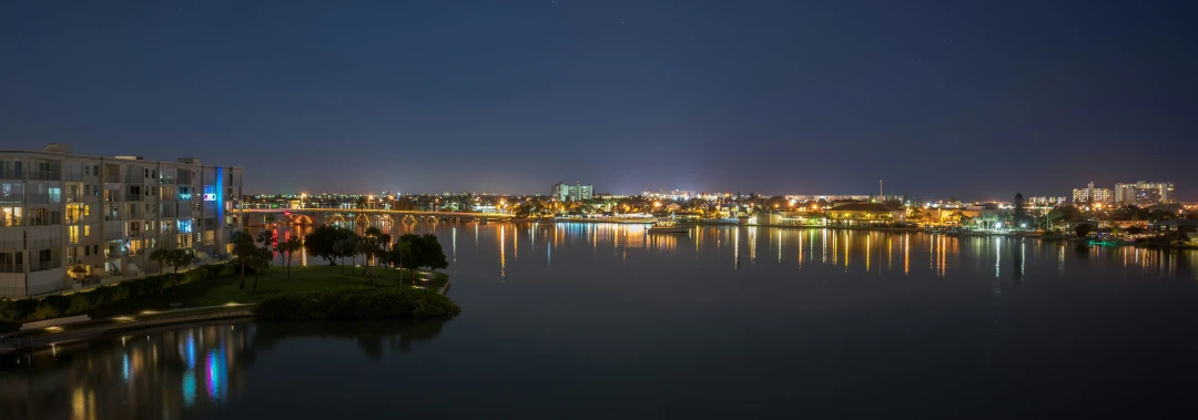 a city is seen at night along the water