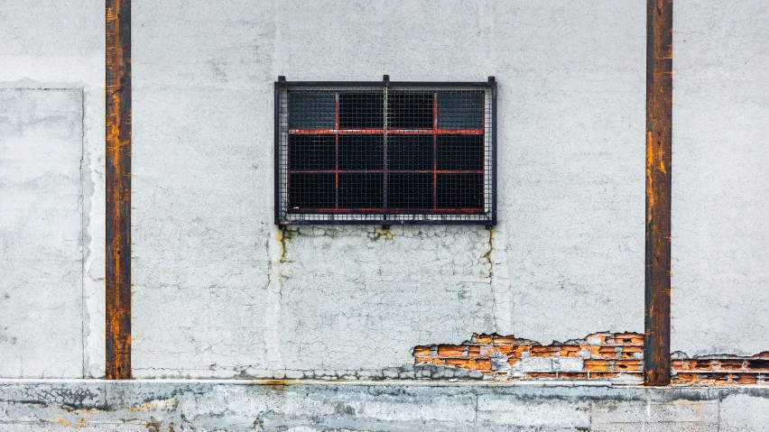 an old window sits on the side of a white wall