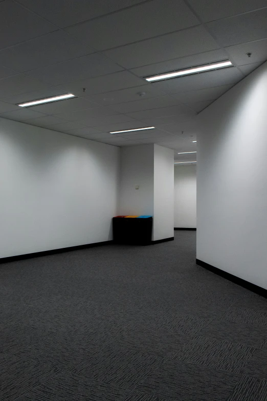 an empty room with white walls and black carpet