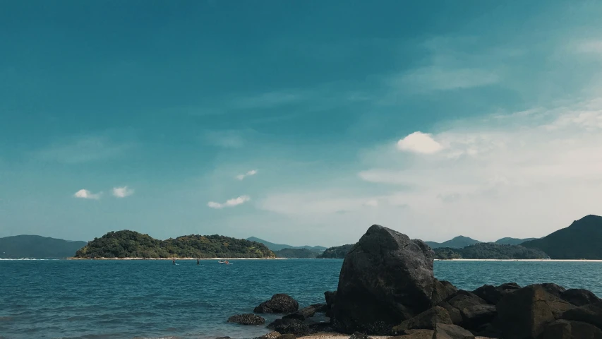 a view from the shore of some small islands