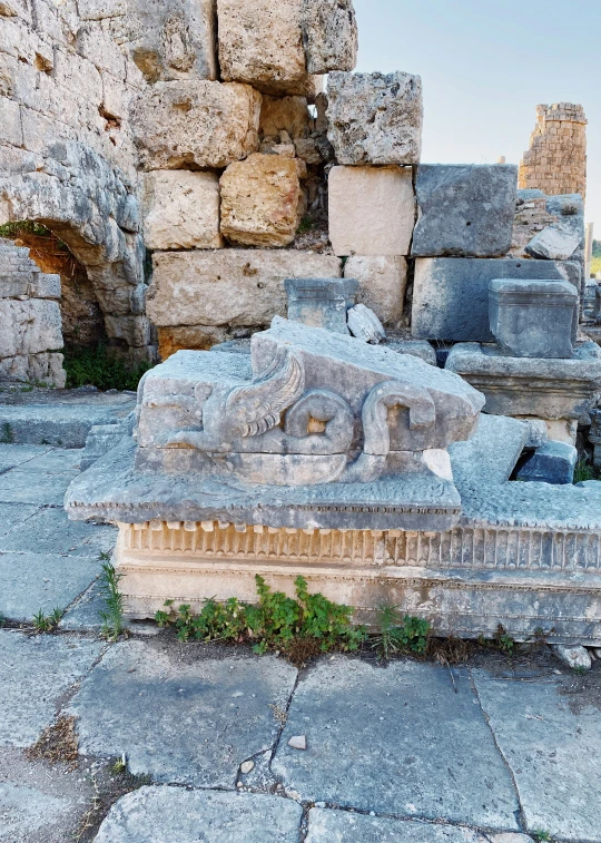 the sculpture of the catacouary, a cat with its head down, is displayed in front of two columns with a wall behind it