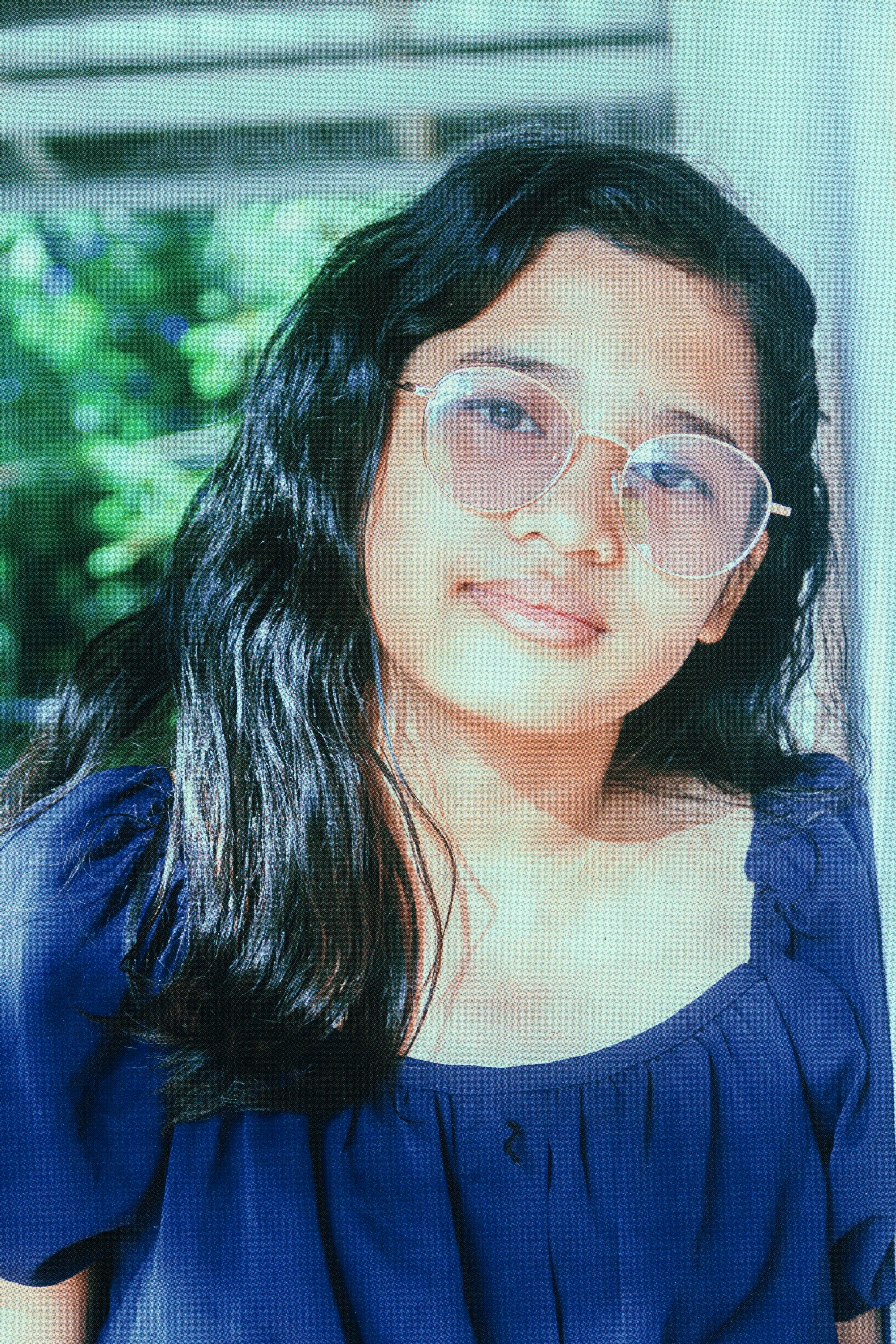 a woman smiling while standing in front of a window