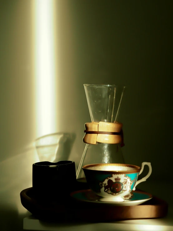 a coffee pot sitting next to a glass vase