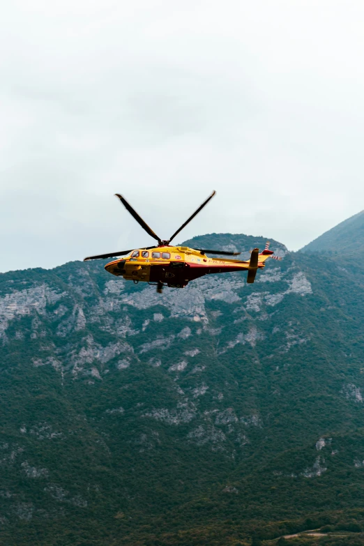 a small plane flying in the air by some mountains