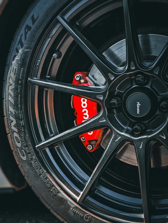 an image of car wheels with red spokes