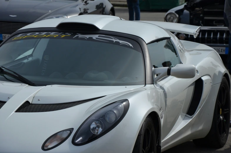 a white sports car is parked next to a building