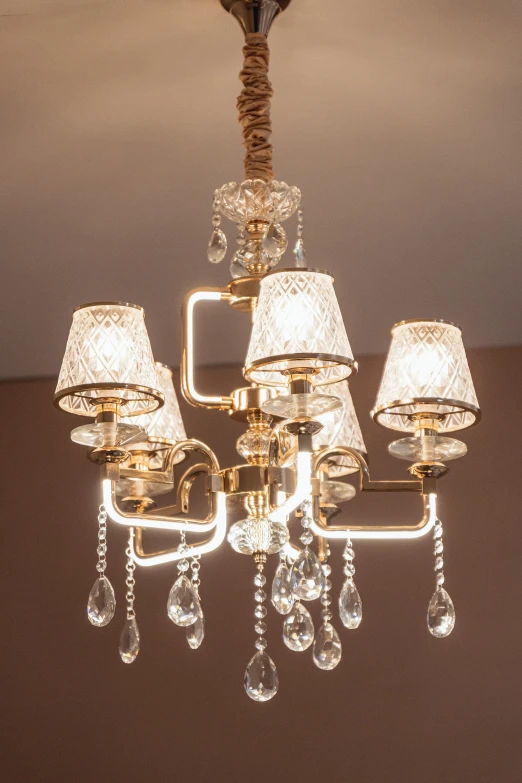 a chandelier with crystal shades and lampshades hanging from it