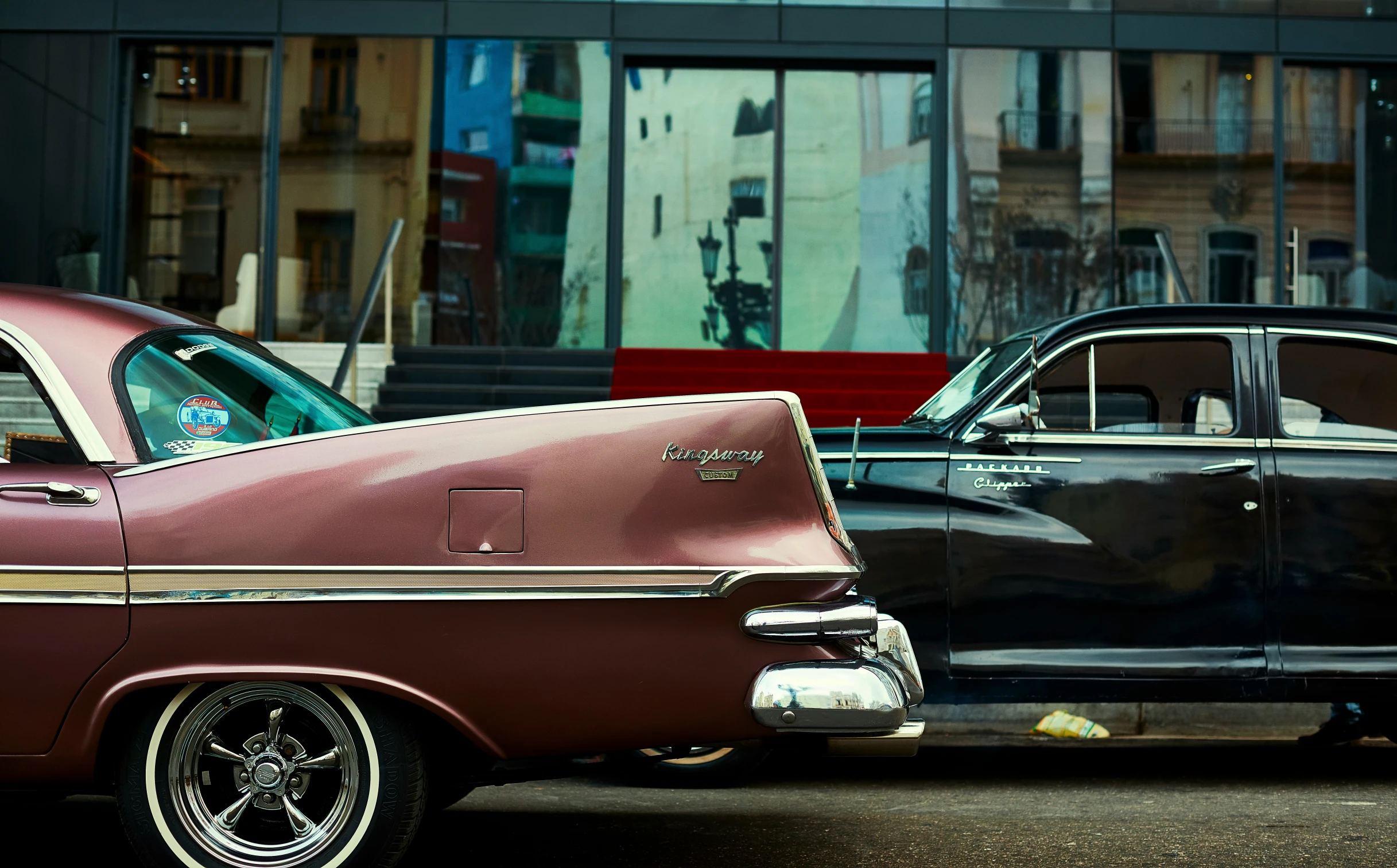 an old fashioned car sitting next to a classic car