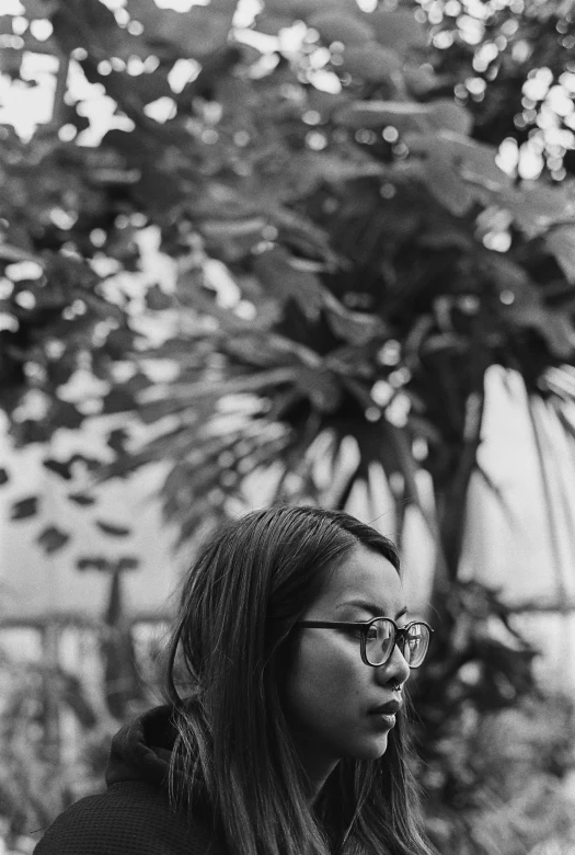 a black and white image of a woman wearing glasses