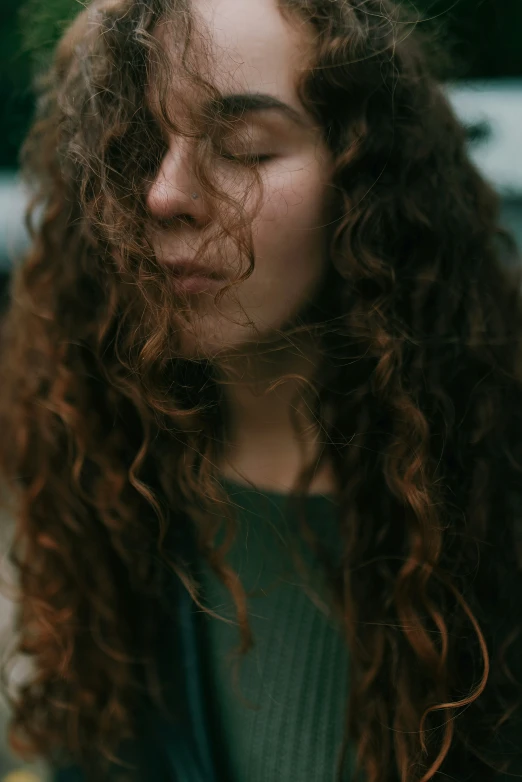 the woman with long, curly hair has closed eyes