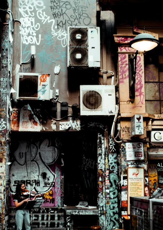 a person standing in front of a graffiti covered building