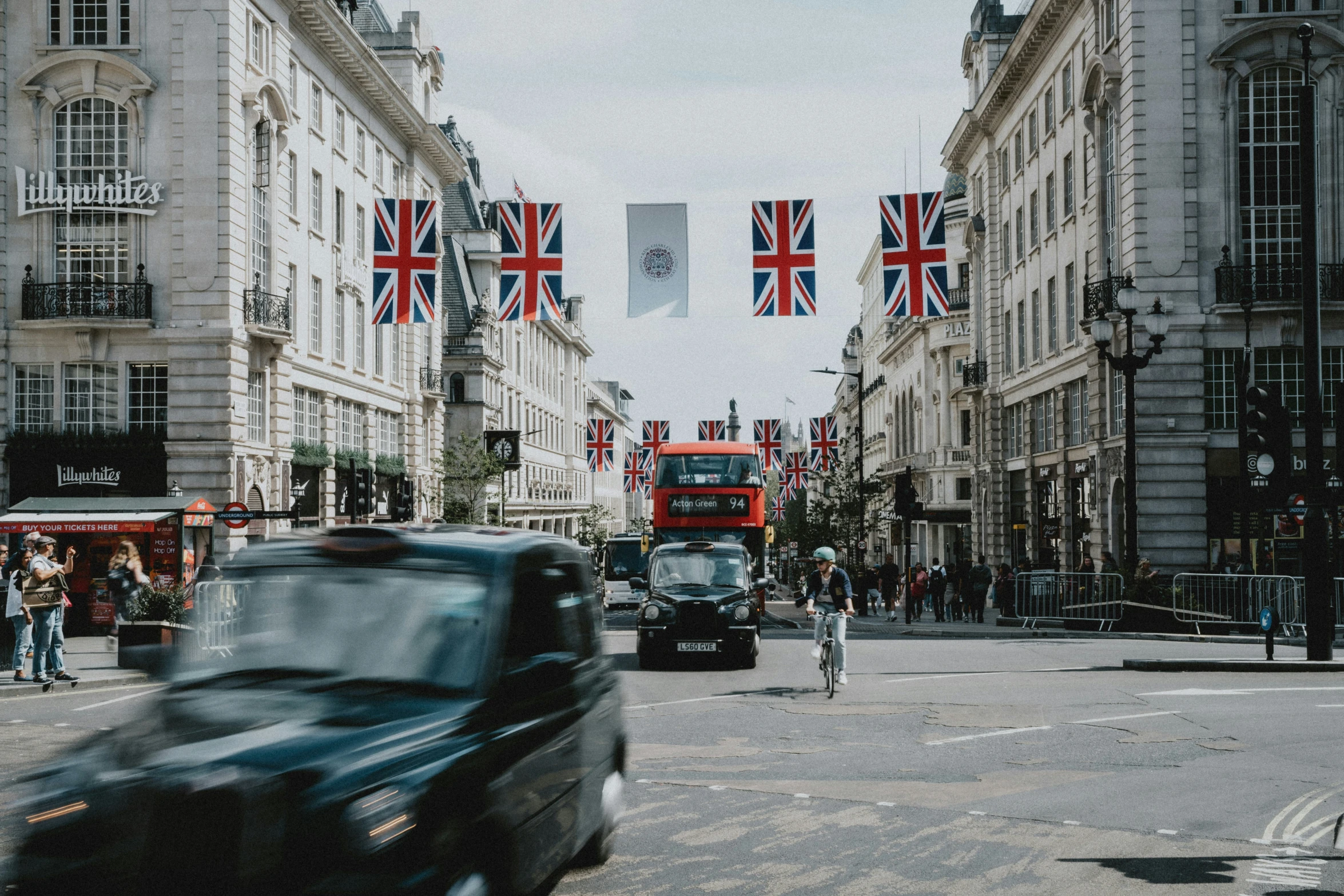 the busy road has many british flags flying above it