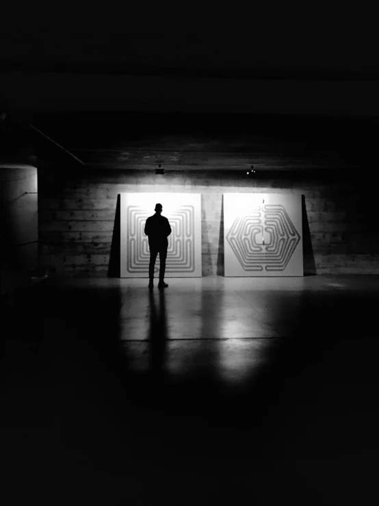 man in front of two squares in the dark