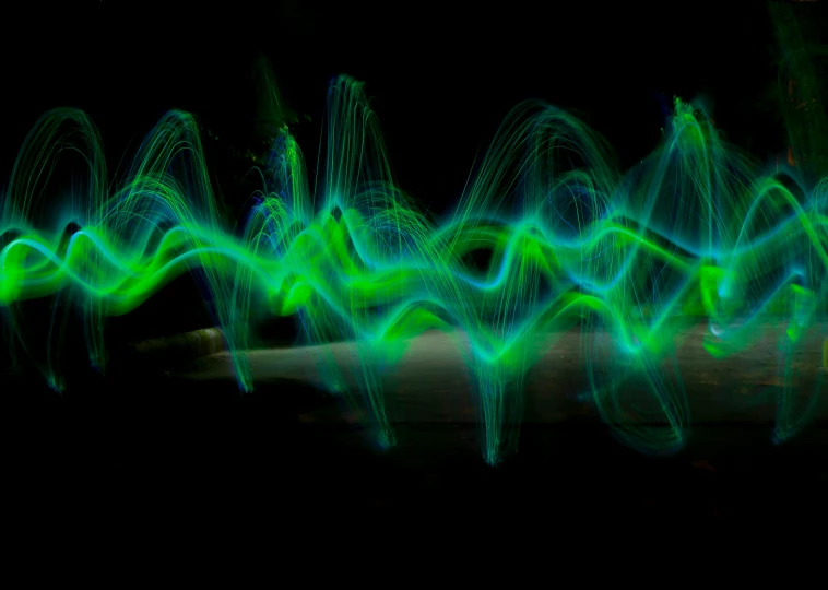 light painting in green and blue, which includes flowing sound waves