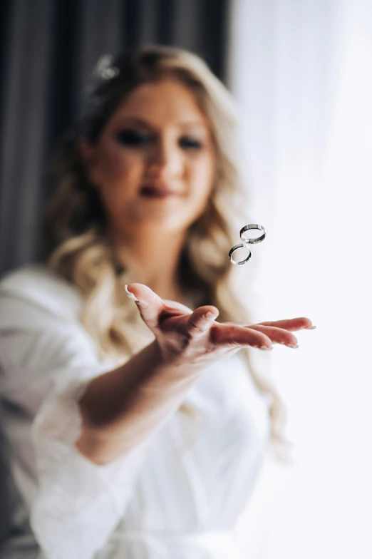 a woman wearing white holding out her hands with a slice of fruit