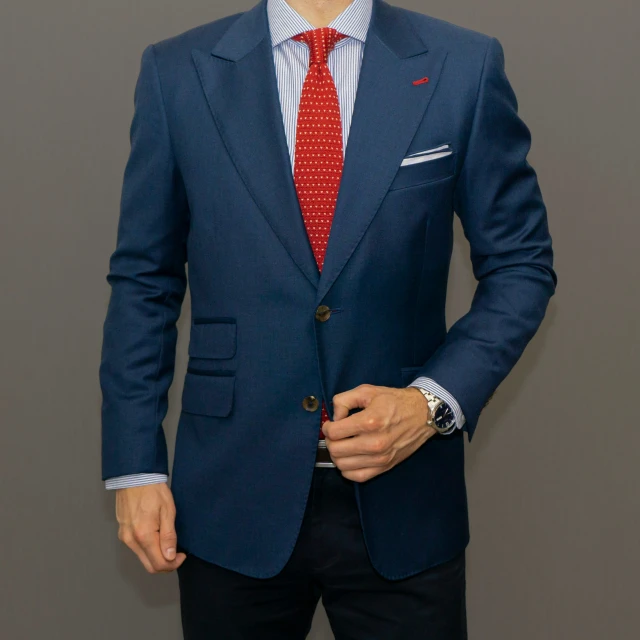 a man in a blue suit and red tie wearing a red tie