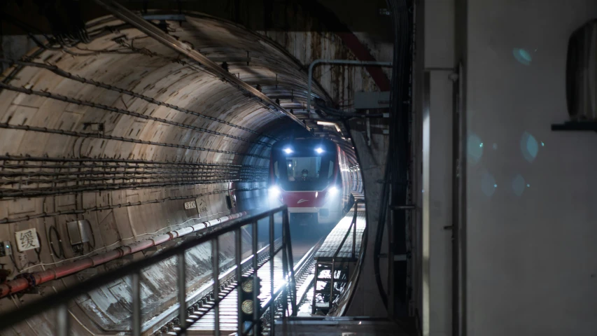 a train coming into the tunnel in the night